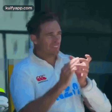 A Man In A White Shirt Is Clapping His Hands GIF