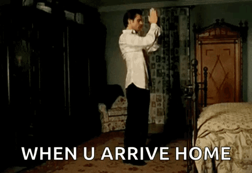 A Man In A White Shirt Is Dancing In A Bedroom With The Words " When U Arrive Home " Below Him GIF