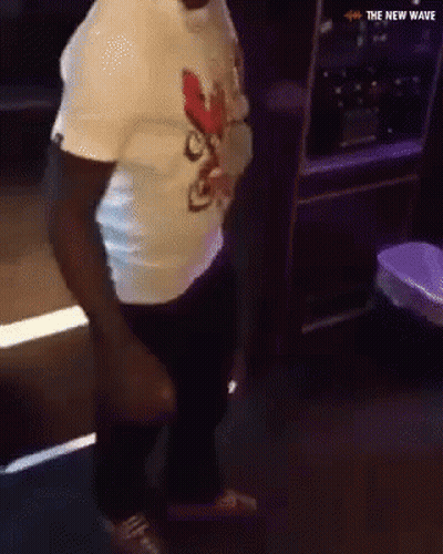 A Man In A White Shirt Is Dancing In A Dark Room With The New Wave Written On The Bottom GIF