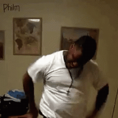 A Man In A White Shirt Is Dancing In A Room With The Name Philm Written On The Wall GIF