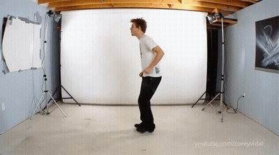 A Man In A White Shirt Is Dancing In A Room With Youtube.com/coreyvidal Written In The Corner GIF