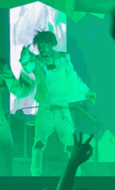 A Man In A White Shirt Is Dancing In Front Of A Green Screen GIF
