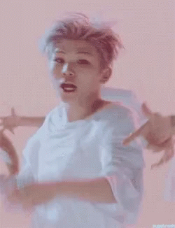 A Man In A White Shirt Is Dancing In Front Of A Group Of Men GIF