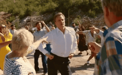 A Man In A White Shirt Is Dancing With A Group Of People In A Crowd . GIF