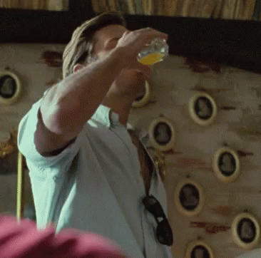 A Man In A White Shirt Is Drinking From A Glass GIF