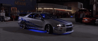A Man In A White Shirt Is Driving A Car With Blue Lights GIF