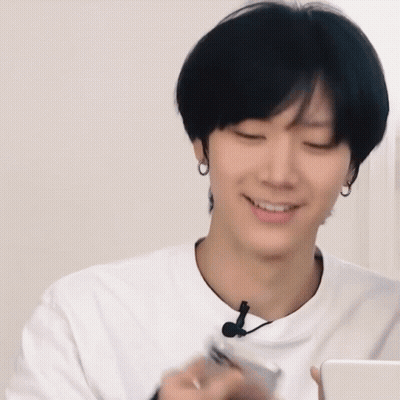 A Man In A White Shirt Is Holding A Cell Phone GIF