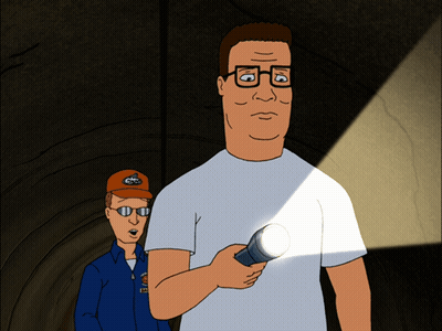 A Man In A White Shirt Is Holding A Flashlight Next To A Man In A Blue Jacket GIF