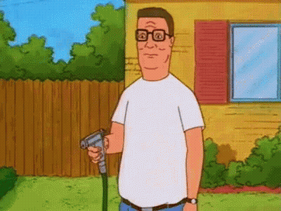 A Man In A White Shirt Is Holding A Hose In His Hand In Front Of A House . GIF