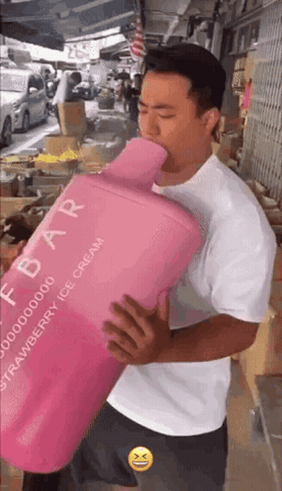 A Man In A White Shirt Is Holding A Large Pink Bottle Of Strawberry Ice Cream GIF
