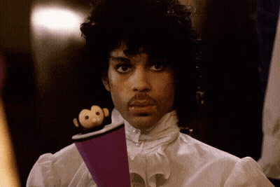 A Man In A White Shirt Is Holding A Purple Object GIF