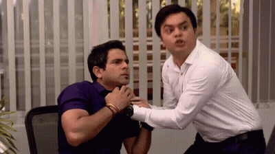 A Man In A White Shirt Is Holding Another Man In A Purple Shirt GIF