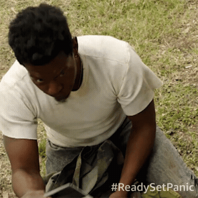 A Man In A White Shirt Is Kneeling Down In The Grass With The Hashtag #Readysetpanic On The Bottom GIF