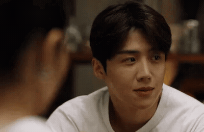 A Man In A White Shirt Is Looking At A Woman In A Mirror . GIF