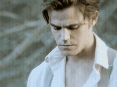 A Man In A White Shirt Is Looking Down With His Eyes Closed GIF