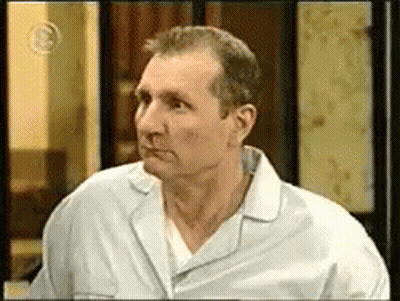 A Man In A White Shirt Is Looking To The Left GIF