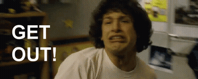 A Man In A White Shirt Is Making A Face And Says Get Out GIF