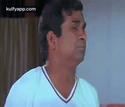 A Man In A White Shirt Is Making A Face . GIF