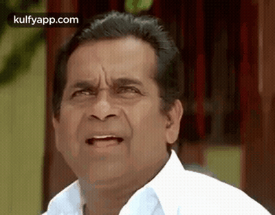 A Man In A White Shirt Is Making A Funny Face And Making A Funny Face . GIF