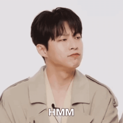 A Man In A White Shirt Is Making A Funny Face And The Word Hmm Is On The Bottom GIF