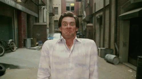 A Man In A White Shirt Is Making A Funny Face In A Alleyway GIF