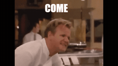 A Man In A White Shirt Is Making A Funny Face In A Kitchen With The Word Come Written On The Screen . GIF
