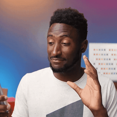 A Man In A White Shirt Is Making A Funny Face While Holding A Cell Phone GIF