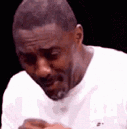 A Man In A White Shirt Is Making A Funny Face While Looking Down . GIF