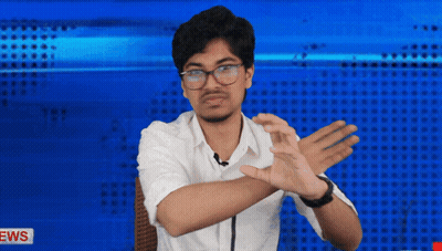 A Man In A White Shirt Is Making A Gesture With His Hands In Front Of A News Background GIF