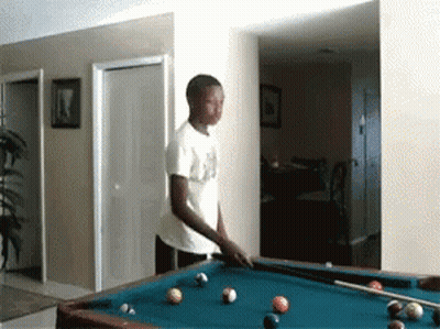 A Man In A White Shirt Is Playing Pool In A Room GIF