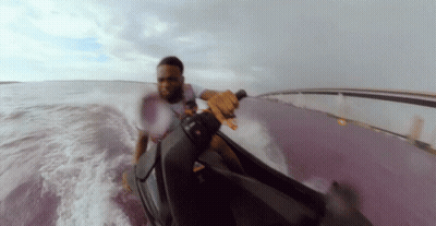 A Man In A White Shirt Is Riding A Jet Ski GIF