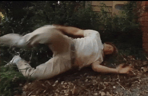 A Man In A White Shirt Is Rolling On The Ground GIF
