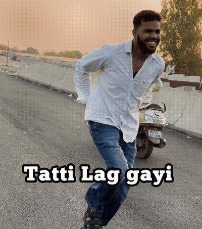 A Man In A White Shirt Is Running Down The Road With The Words Tatti Lag Gayi Written Below Him GIF