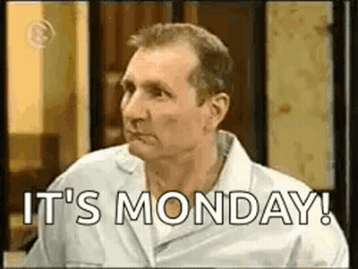 A Man In A White Shirt Is Saying `` It 'S Monday '' While Sitting In A Room . GIF