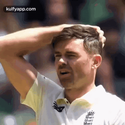 A Man In A White Shirt Is Scratching His Head With His Hands . GIF
