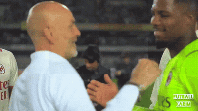 A Man In A White Shirt Is Shaking Hands With A Man In A Green Shirt With The Word Futball Karim On It GIF