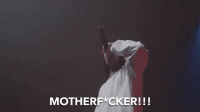 A Man In A White Shirt Is Singing Into A Microphone And The Words Motherfucker Are Above Him GIF