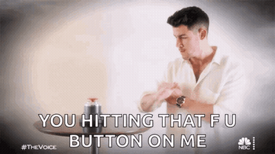 A Man In A White Shirt Is Sitting At A Table And Saying You Hitting That Fu Button On Me GIF