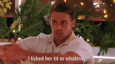 A Man In A White Shirt Is Sitting In Front Of A Window And Talking To Someone . GIF
