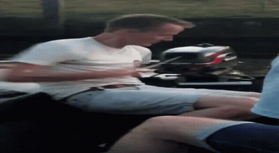 A Man In A White Shirt Is Sitting On A Boat Next To A Boat Motor . GIF