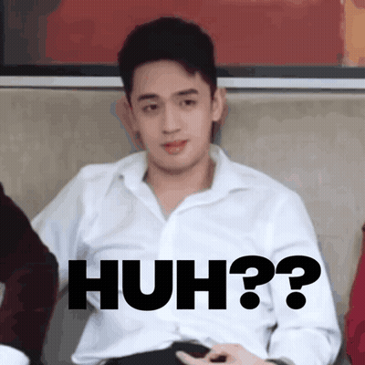 A Man In A White Shirt Is Sitting On A Couch With The Words Huh Written On His Chest GIF