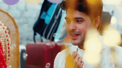 A Man In A White Shirt Is Smiling In Front Of A Bride In A Red Dress . GIF