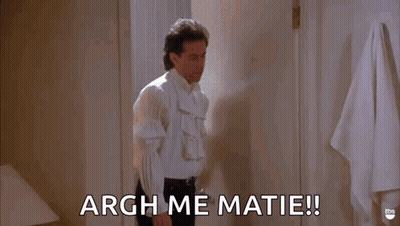 A Man In A White Shirt Is Standing In A Bathroom And Saying Argh Me Matie ! GIF