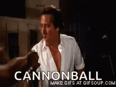 A Man In A White Shirt Is Standing In A Dark Room With A Cannonball Gif . GIF