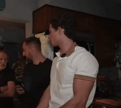 A Man In A White Shirt Is Standing In A Kitchen With Other Men GIF