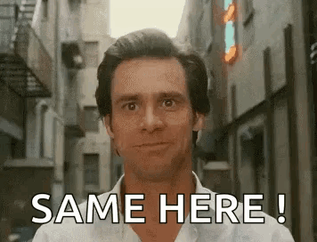 A Man In A White Shirt Is Standing In A Narrow Alleyway . GIF