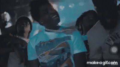 A Man In A White Shirt Is Standing In Front Of A Crowd With Make A Gif.com On The Bottom Right GIF