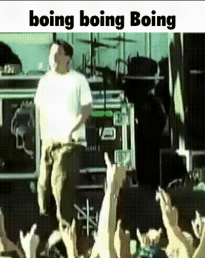 A Man In A White Shirt Is Standing In Front Of A Crowd With The Words Boing Boing Boing Written Below Him GIF