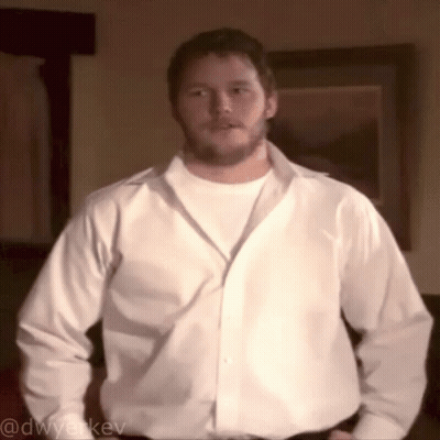 A Man In A White Shirt Is Standing In Front Of A Framed Picture And Has The Username @Dwyerkev On The Bottom GIF