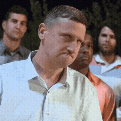 A Man In A White Shirt Is Standing In Front Of A Group Of Men GIF